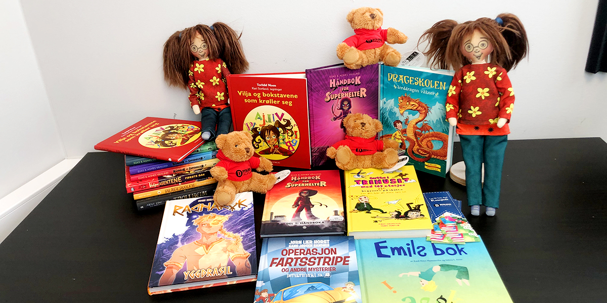 Barnebøker og to dukker med musefletter utstilt på et bord