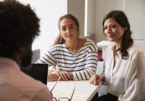 Mother And Daughter Meeting With Male Teacher