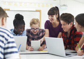 Teenage Students With Teacher In IT Class